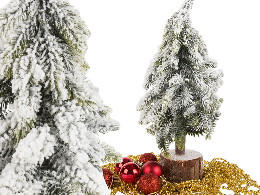 Mākslīgā Ziemassvētku eglīte ar sniegu, mazs dekoratīvs rakstāmgalds uz bieza, sniegota stumbra