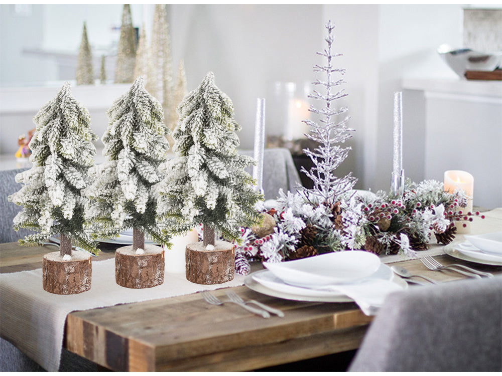 Mākslīgā Ziemassvētku eglīte ar sniegu, mazs dekoratīvs rakstāmgalds uz bieza, sniegota stumbra