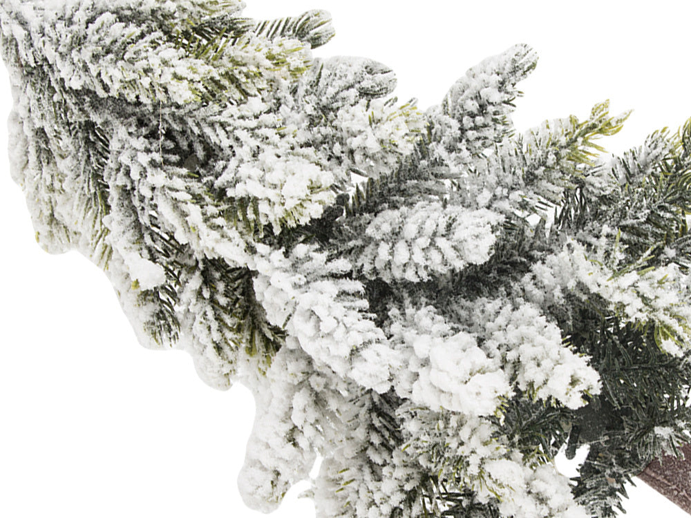 Mākslīgā Ziemassvētku eglīte ar sniegu, mazs dekoratīvs rakstāmgalds uz bieza, sniegota stumbra