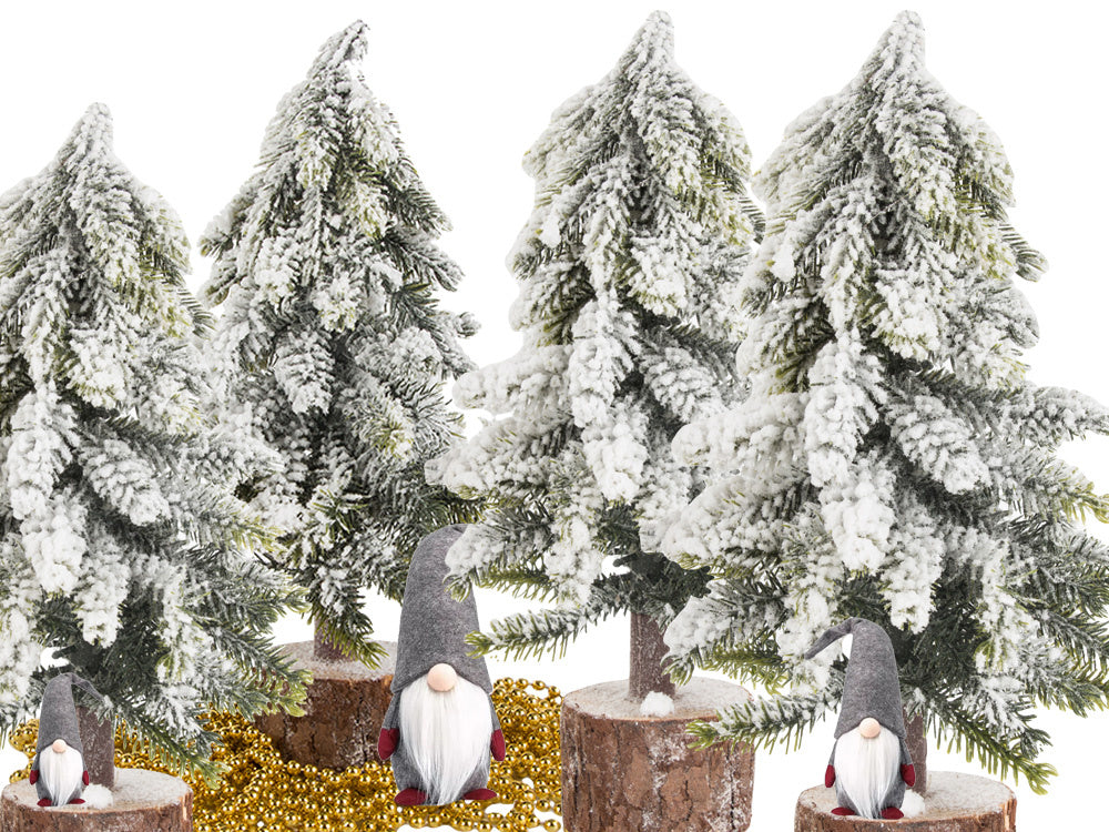 Mākslīgā Ziemassvētku eglīte ar sniegu, mazs dekoratīvs rakstāmgalds uz bieza, sniegota stumbra