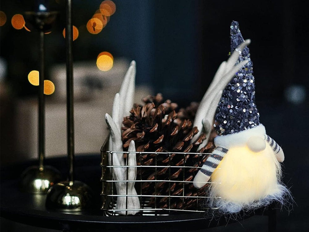 Rūķa rūķītis ar apgaismotu LED vēdera Ziemassvētku rūķīti zem Ziemassvētku eglītes